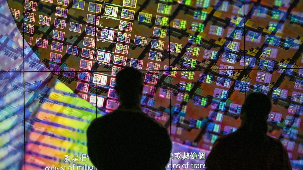 Visitors watch a wafer shown on screens at the Taiwan Semiconductor Manufacturing Company.
