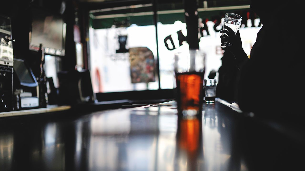 A man drinks a pint of beer in Te Olde Kings Head Pub, Santa Monican, Los Angeles, USA